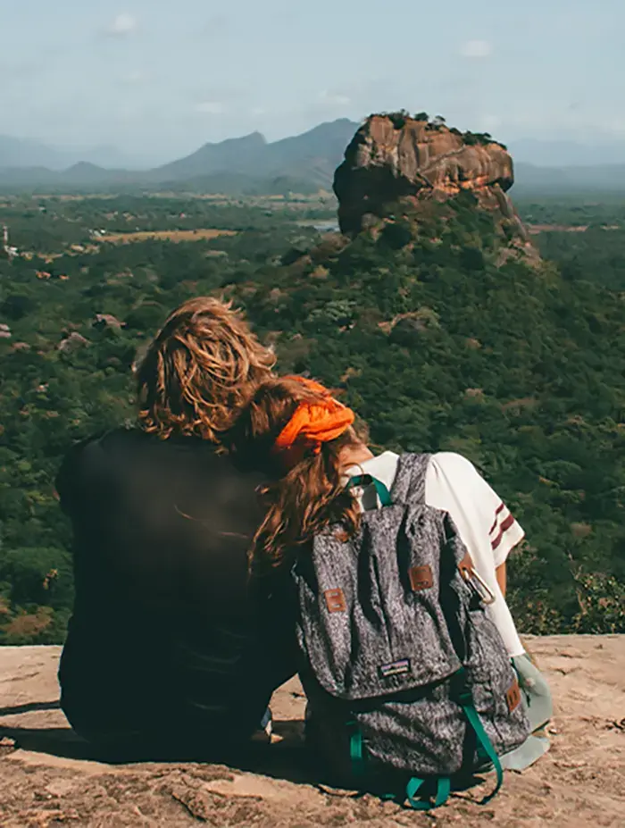 Ein junges Paar blickt zusammen in eine grüne Landschaft mit Bergen
